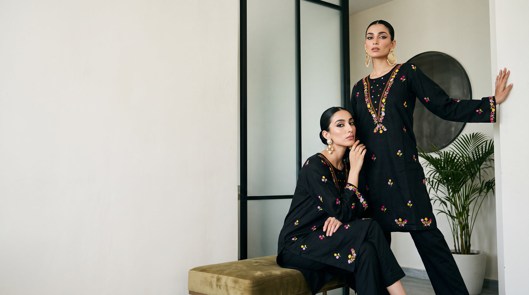 Two models wearing black embroidered Funkar outfits
